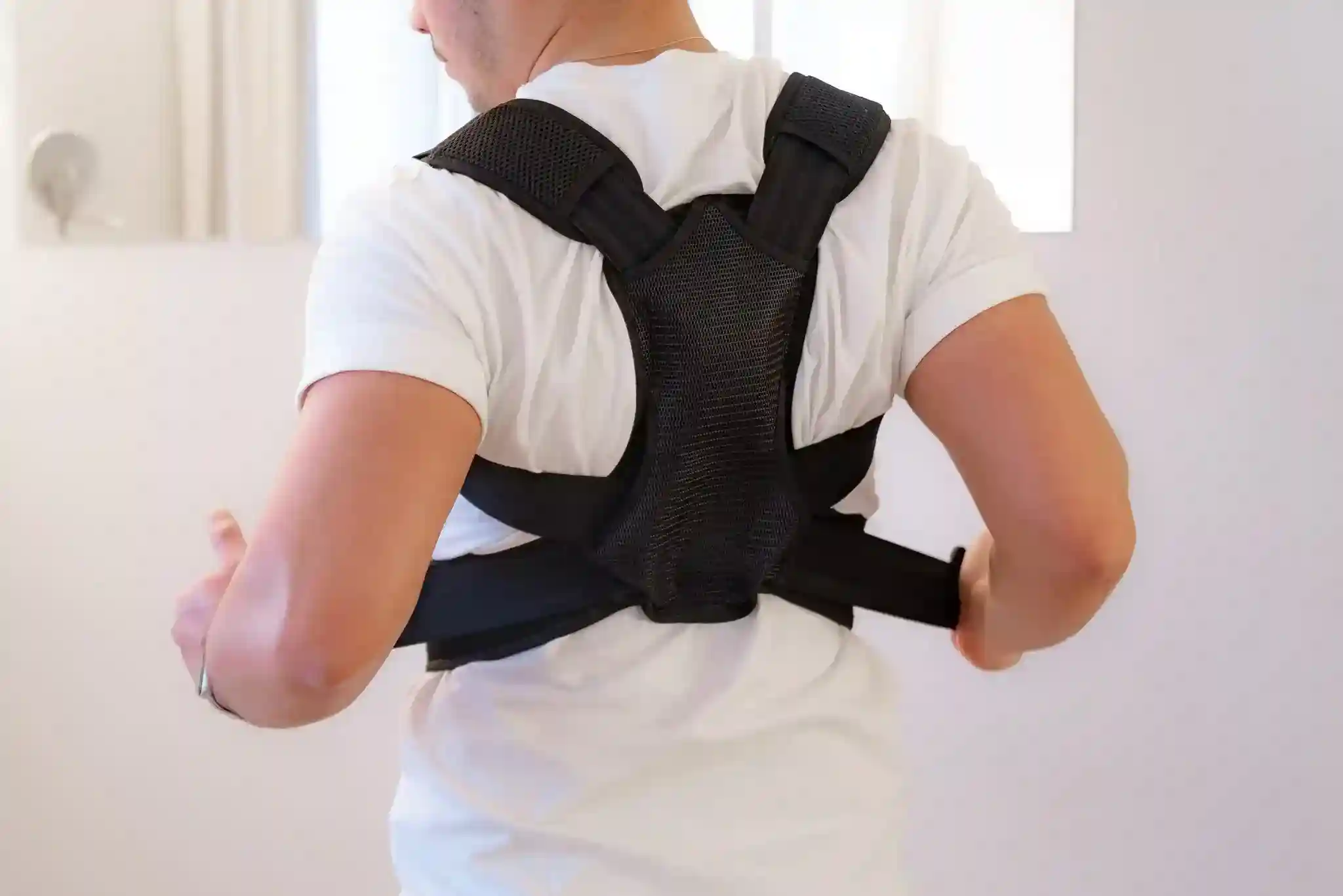 Person wearing a posture corrector, demonstrating improved posture and comfort